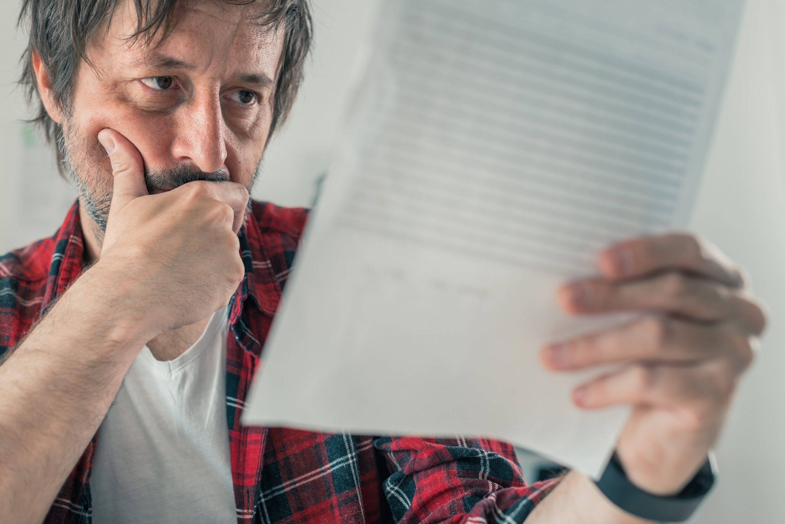worried freelancer reading business contract and t FZXW56W min scaled